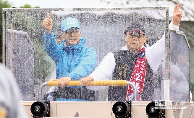 國民黨候選人朱立倫（左）6日陪同“立委”候選人張慶忠（右）以車隊冒雨掃街，透過防彈宣傳車隱約呈現兩人輪廓