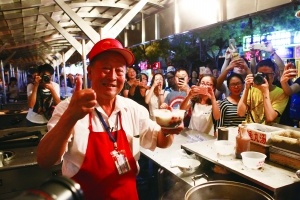 昨夜是東華門夜市營業的最后一晚。待收攤后,東城城管委在街兩端設立警示燈,施工單位進場設立圍擋,啟動道路改造工程。圖為賣了32年魚丸的滕老爺子昨晚賣完最后一碗,和老食客告別。北京晨報記者 王穎/攝