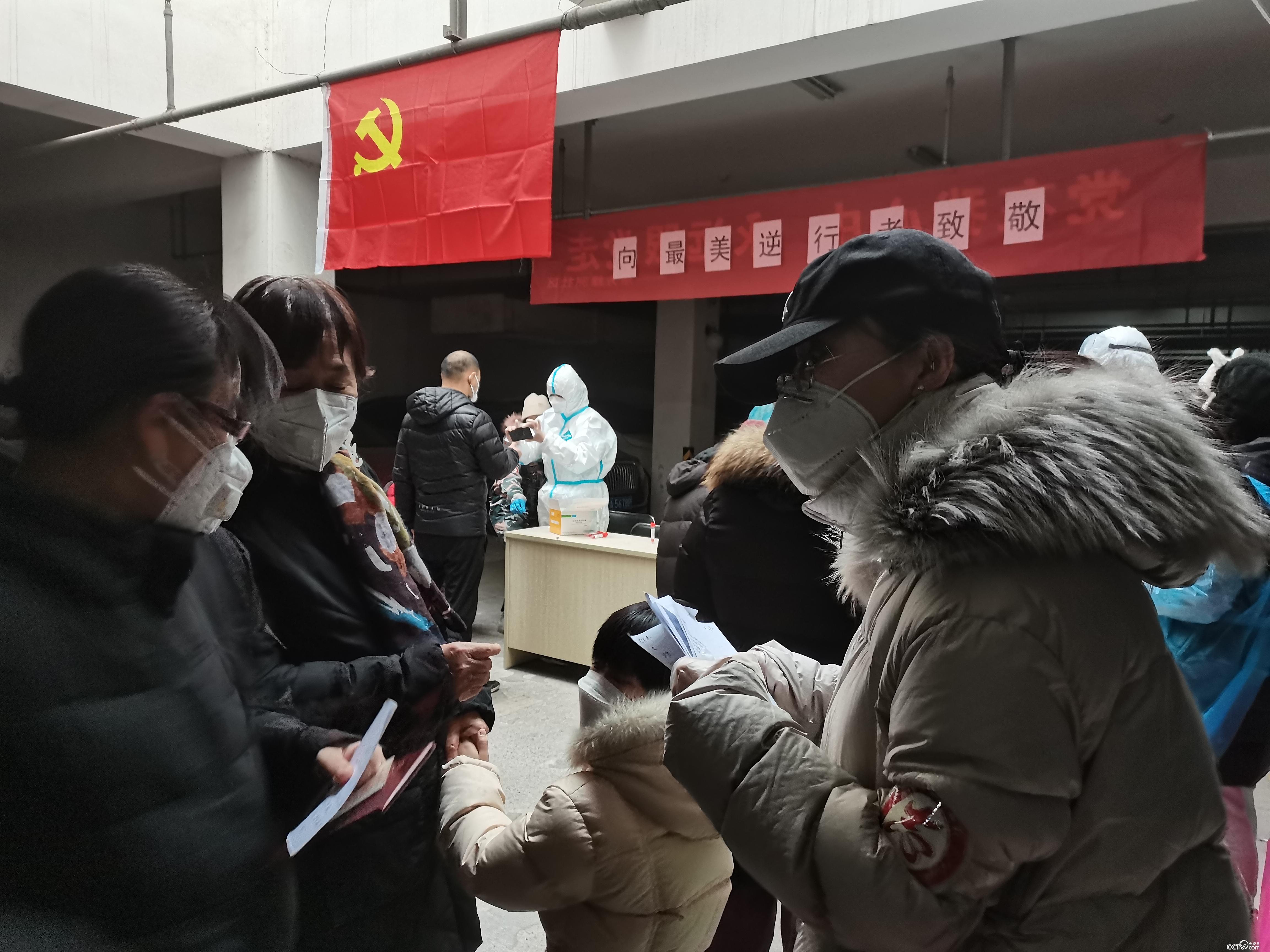 石家莊市裕華區尚東綠洲小區志愿者在石家莊市第二輪全員核酸檢測采樣點,協助醫務人員工作。(攝/徐輝)