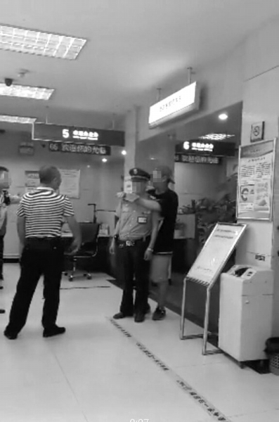 男子正持刀挾持銀行保安。網(wǎng)絡(luò)圖片