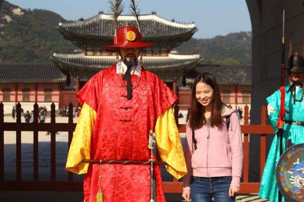 在韓國首爾景福宮外，中國游客與韓國守城門將合影。