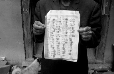 候見志父親展示村民們的聯名請愿書。
