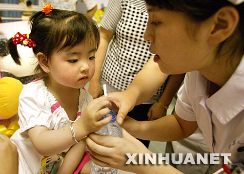  5月31日，江蘇省人民醫院的護士在愛心病房喂宋馨懿喝水。當日傍晚，四川地震災區小傷員宋馨懿來到南京，進入江蘇省人民醫院接受身體和心理的康復治療，并為安裝假肢做準備。 5月14日，在地震后的四川北川縣城，被壓在垮塌房屋下的3歲小女孩宋馨懿，在遇難父母的身體翼護下與死神抗爭了40多個小時后獲救。在醫療隊和社會各界關照下，小馨懿的身心恢復狀況良好。