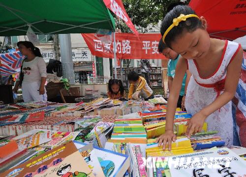  6月7日，一位小朋友在綿竹市街頭的綿竹市圖書館臨時閱覽點看書。     記者在四川地震災區(qū)看到，災區(qū)群眾沒有被災難壓垮，他們的生活正在從災難中逐步恢復起來，災區(qū)處處展露生機。 　